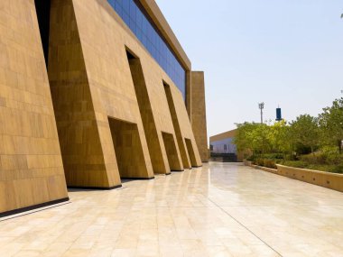 Riyad, Suudi Arabistan 'ın modern ticaret bölgesi. Suudi Arabistan 'ın Riyad kentindeki modern bir alışveriş ve ticaret bölgesinin çarpıcı manzarası. Mimari geometrik şekilleri, yeşilliği ve zarifliği harmanlıyor.