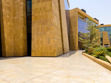 Riyad, Suudi Arabistan 'ın modern ticaret bölgesi. Suudi Arabistan 'ın Riyad kentindeki modern bir alışveriş ve ticaret bölgesinin çarpıcı manzarası. Mimari geometrik şekilleri, yeşilliği ve zarifliği harmanlıyor.