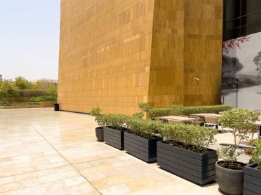 Riyad, Suudi Arabistan 'ın modern ticaret bölgesi. Suudi Arabistan 'ın Riyad kentindeki modern bir alışveriş ve ticaret bölgesinin çarpıcı manzarası. Mimari geometrik şekilleri, yeşilliği ve zarifliği harmanlıyor.