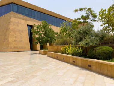 Riyad, Suudi Arabistan 'ın modern ticaret bölgesi. Suudi Arabistan 'ın Riyad kentindeki modern bir alışveriş ve ticaret bölgesinin çarpıcı manzarası. Mimari geometrik şekilleri, yeşilliği ve zarifliği harmanlıyor.