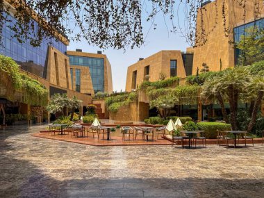 Riyad, Suudi Arabistan 'ın modern ticaret bölgesi. Suudi Arabistan 'ın Riyad kentindeki modern bir alışveriş ve ticaret bölgesinin çarpıcı manzarası. Mimari geometrik şekilleri, yeşilliği ve zarifliği harmanlıyor.