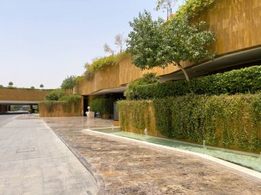 Riyad, Suudi Arabistan 'ın modern ticaret bölgesi. Suudi Arabistan 'ın Riyad kentindeki modern bir alışveriş ve ticaret bölgesinin çarpıcı manzarası. Mimari geometrik şekilleri, yeşilliği ve zarifliği harmanlıyor.