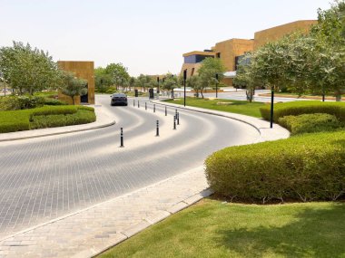 Riyad, Suudi Arabistan 'ın modern ticaret bölgesi. Suudi Arabistan 'ın Riyad kentindeki modern bir alışveriş ve ticaret bölgesinin çarpıcı manzarası. Mimari geometrik şekilleri, yeşilliği ve zarifliği harmanlıyor.