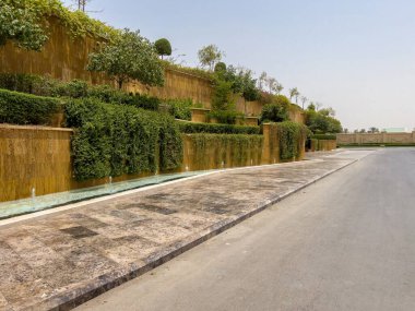 Riyad, Suudi Arabistan 'ın modern ticaret bölgesi. Suudi Arabistan 'ın Riyad kentindeki modern bir alışveriş ve ticaret bölgesinin çarpıcı manzarası. Mimari geometrik şekilleri, yeşilliği ve zarifliği harmanlıyor.