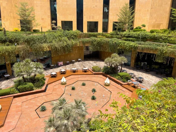 Riyad, Suudi Arabistan 'ın modern ticaret bölgesi. Suudi Arabistan 'ın Riyad kentindeki modern bir alışveriş ve ticaret bölgesinin çarpıcı manzarası. Mimari geometrik şekilleri, yeşilliği ve zarifliği harmanlıyor.