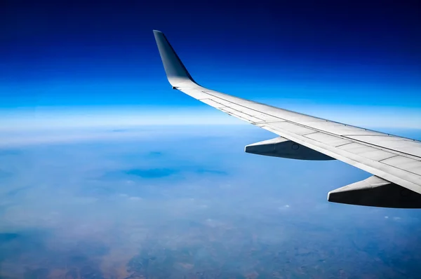 Ala de avião voando acima das nuvens no céu — Fotografia de Stock