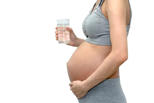 Primer plano de una linda mujer embarazada del vientre con un vaso de agua. Yo... — Foto de Stock