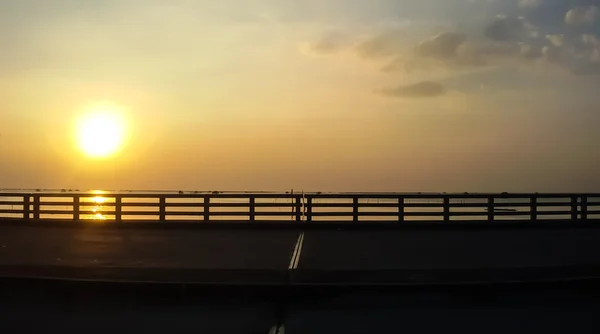 Straßenbrücke über dem Meer bei Sonnenaufgang — Stockfoto