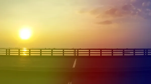 Pont routier sur la mer au lever du soleil dans un ton vintage — Photo