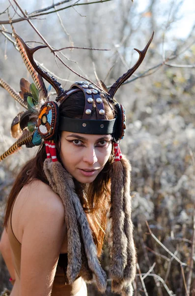 Chica moderna de estilo indio en un sombrero con cuernos y plumas —  Fotos de Stock