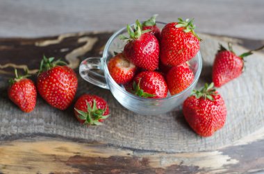 Çilek ve ahşap zemin üzerine bir bardak buz küpleri