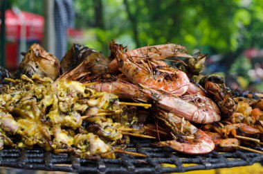 Ahşap sopa üzerinde ızgara deniz ürünleri (karides ve mürekkep) 