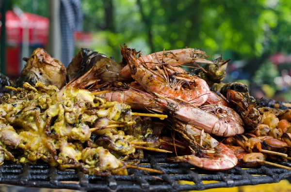 Ahşap sopa üzerinde ızgara deniz ürünleri (karides ve mürekkep) 