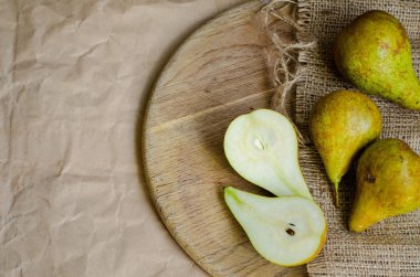 Kağıt, ambalaj arka plan üzerinde olgunlaşmış ve sulu armut tuval çuval bezi ve tonda ve soluk ahşap masa,