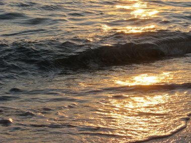 Dalgalar deniz günbatımı üzerinde