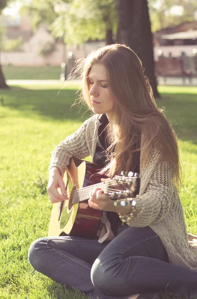 Long-haired blond girl posing with a guitar — Stock Photo, Image