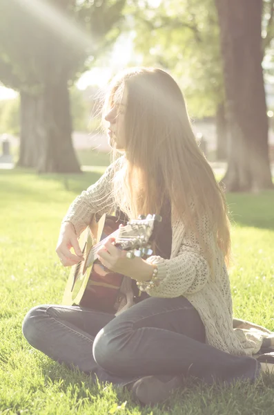Όμορφο μακρυμάλλης κορίτσι παίζει μια ακουστική κιθάρα — Φωτογραφία Αρχείου