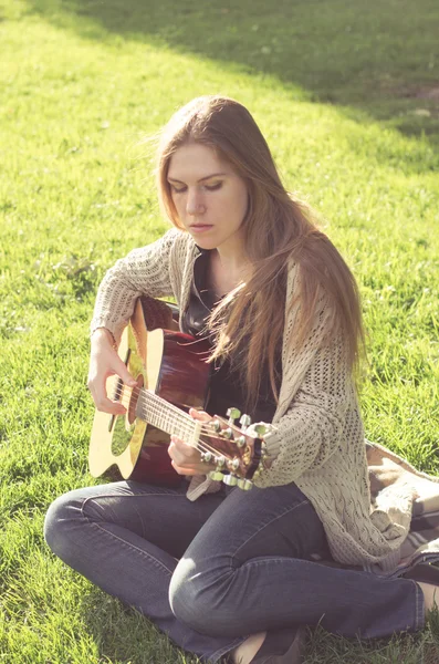 Güzel uzun saçlı kız bir akustik gitar çalmak — Stok fotoğraf