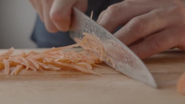 Chef schneidet Karotten für Salat und Wok in der heimischen Küche — Stockvideo