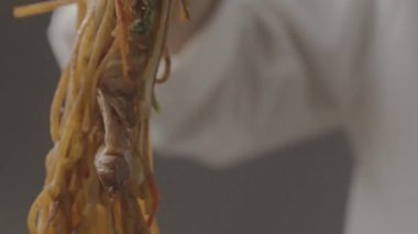 Şef büyük siyah bir tepside restoranın gurme yemeklerinde makarna tavası hazırla.