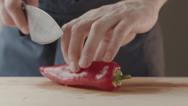 Hombre Chef enciende pimienta con cuchillo para ensalada en la cocina en casa Cocinar — Vídeos de Stock
