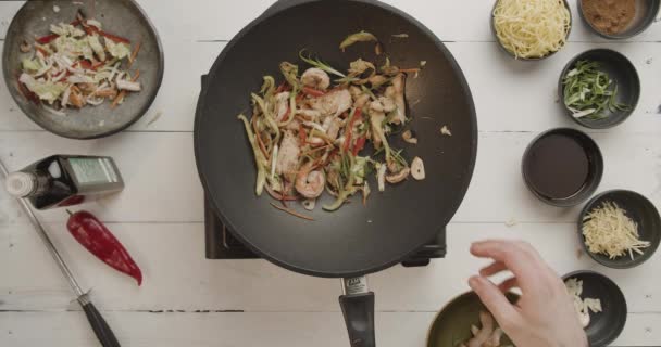 Повар на кухне готовит вок из обжаренных овощей в воке с пламенем — стоковое видео