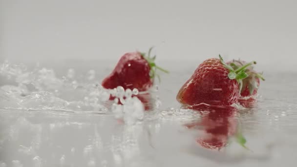 Eco Fresas salpicaduras en cámara lenta con reflejos alimentos dulces orgánicos — Vídeos de Stock