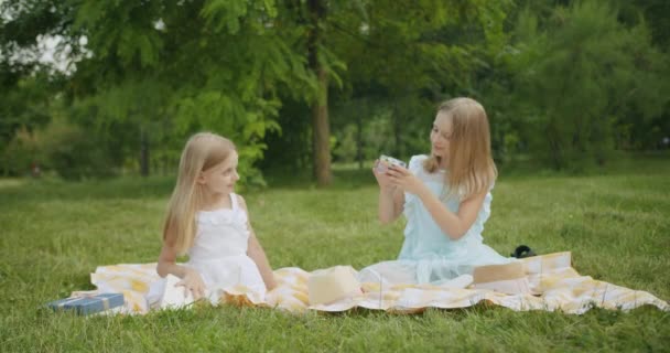 Sesión de fotos de niños con el pelo largo y rubio en el parque sonriendo chicas bonitas — Vídeos de Stock