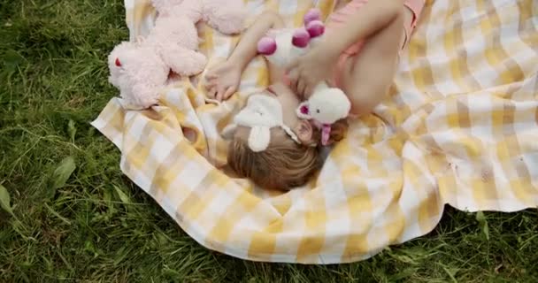 Teen Girl dort sur le parc avec des masques de sommeil et des jouets rembourrés couverture jaune — Video