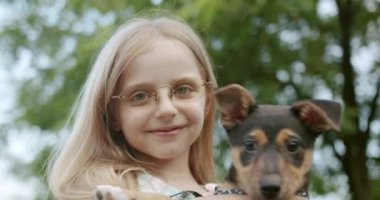 Güzel çocuk parkta evcil hayvan köpeğiyle oynuyor ve eğleniyor.