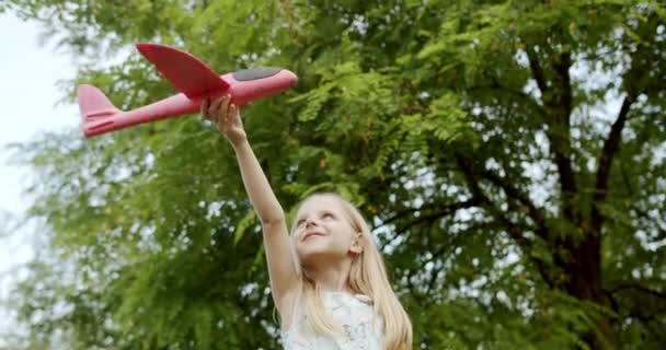 Feliz chica jugar con un juguete avión chica quiere convertirse en piloto y astronauta — Vídeo de stock