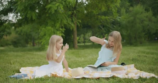 Sessão de fotos de crianças com cabelos longos loiros no parque sorrindo meninas bonitas — Vídeo de Stock