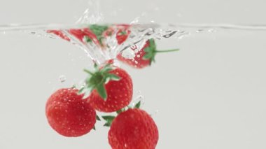 Lezzetli Çilek yavaş çekimde suya düşüyor. Güzel reklam çekimi.