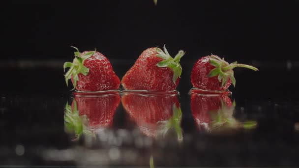 Verse aardbeien spetterend op slow motion met reflecties voor natuurlijk sappig — Stockvideo