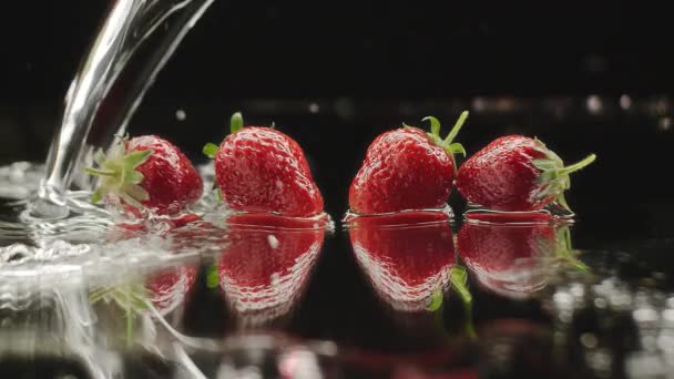 Frische Erdbeeren planschen in Zeitlupe mit Reflexionen für natürliche Saftigkeit — Stockvideo