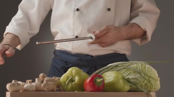 Chef wetzt Messer und Gemüsetisch in der Küche — Stockvideo