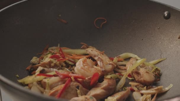 Asijské wok připravené s nudlemi a zeleninou s kuřecími prsy a krevetami — Stock video