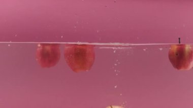 Tatlı elmalar suya düşer ve yemek reklamı için su sıçratır.