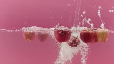 Tatlı elmalar suya düşer ve yemek reklamı için su sıçratır.