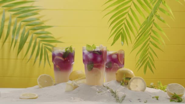 Lemonad cocktail uppfriskande med is och mynta skiva citrus på gul bakgrund — Stockvideo