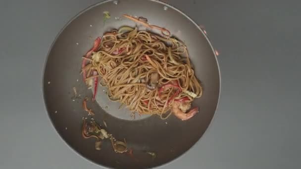 Kuchař Příprava wok smažené nudle s krevetami podávané v černé železné pánvi thajské jídlo — Stock video
