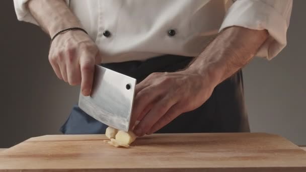 Hombre corte jengibre fresco con cuchillo grande en el interior de la cocina preparar la comida — Vídeos de Stock