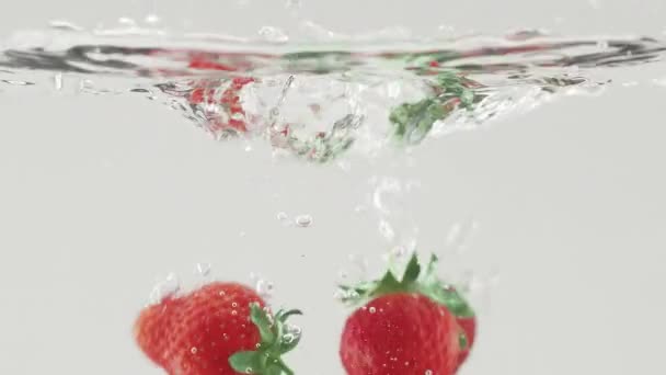 スローモーションで水に落ちるおいしいイチゴ美しい商業的ショット — ストック動画