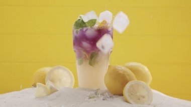 Buzlu limonata kokteyli yaz mevsimi ve sarı arka planda turunçgil dilimi.
