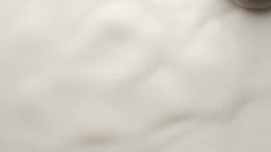  yuvarlak çikolata bir süt kasesine düşer ve taç ve dairesel dalgalar yaratır.