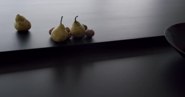 Mesa de madeira preta com alguns marmelos de frutas e em uma tigela na sala de cozinha — Vídeo de Stock