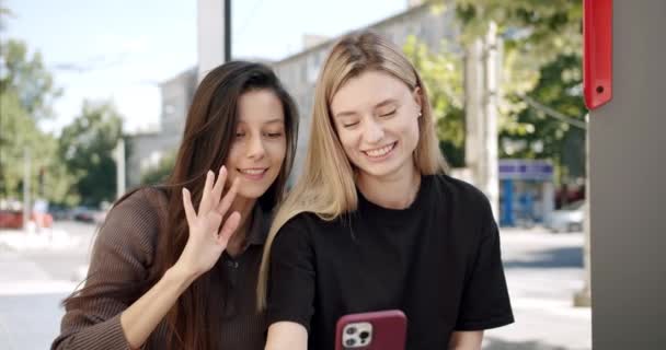 Aantrekkelijke jonge vrouwen die video bellen op een mobiele telefoon maken virtuele kus — Stockvideo