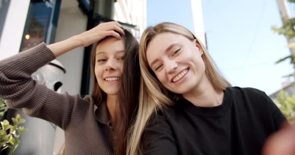 Kobieta pokazuje język, Dwie młode, uśmiechnięte hipsterki latem, robiące selfie — Wideo stockowe