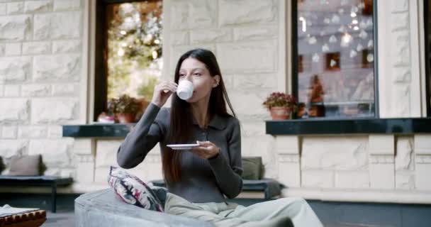 Atractiva dama disfrutando de una taza de café en la calle de la ciudad, al estilo de buenos días — Vídeos de Stock