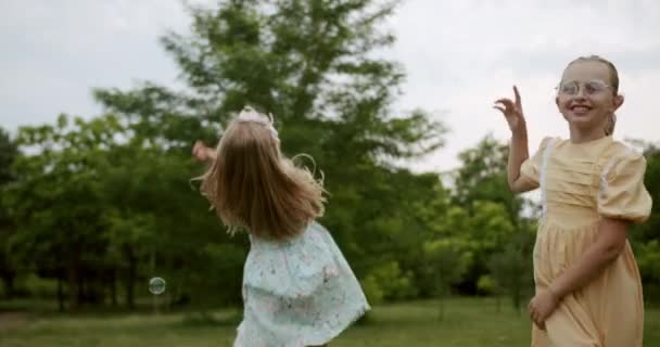 Gyermek fogások szappanbuborékok a parkban szabadban gyerekek álom koncepció boldog — Stock videók